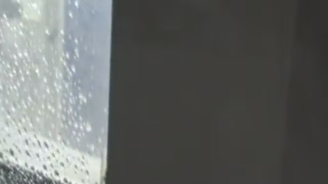 Topless girl in jeans with wet head on window video