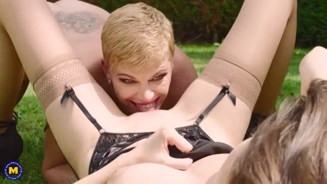 Blonde and brunette are fingering each others pussy while passionately making love in the backyard