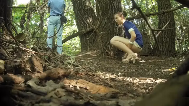 Guy stands on guard as his girlfriend pees behind a tree