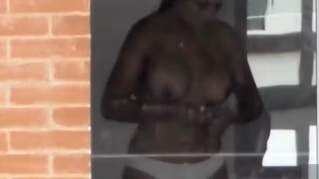 Busty woman filmed in secret while naked next to the window