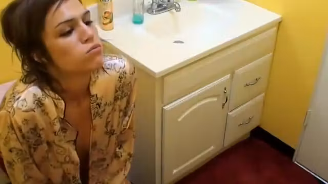 Brunette with a pierced belly takes a pee