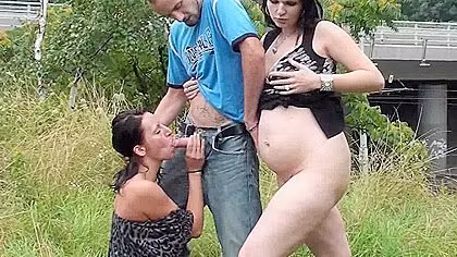 Two brunettes share a cock in nature